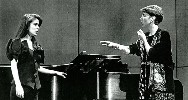 woman teaching a voice student in front of piano